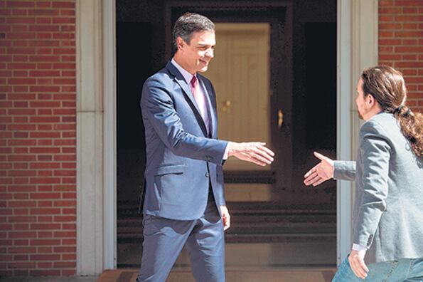 Sánchez e Iglesias se dan la mano antes de reunirse ayer en el Palacio de la Moncloa.