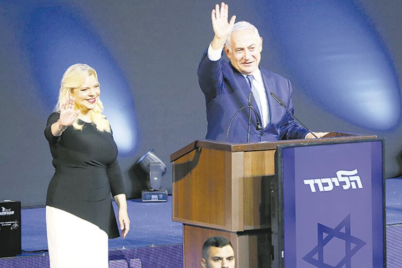 Netanyahu, junto a su esposa Sara, saluda a sus seguidores en el bunker de Likud en Tel Aviv.