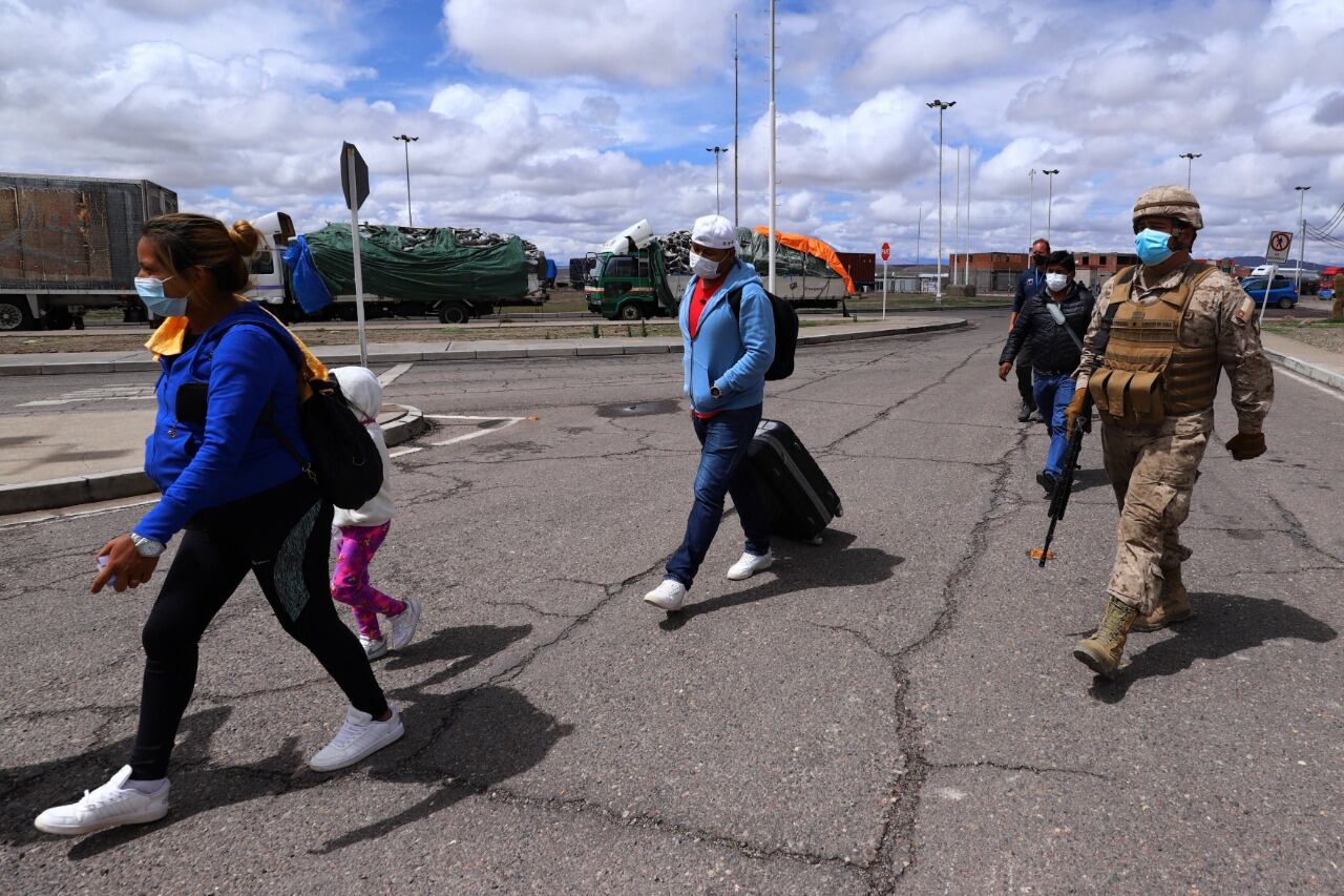 Un Carabinero chileno escolta a un grupo de migrantes en Colchane, cerca de la frontera con Bolivia.
