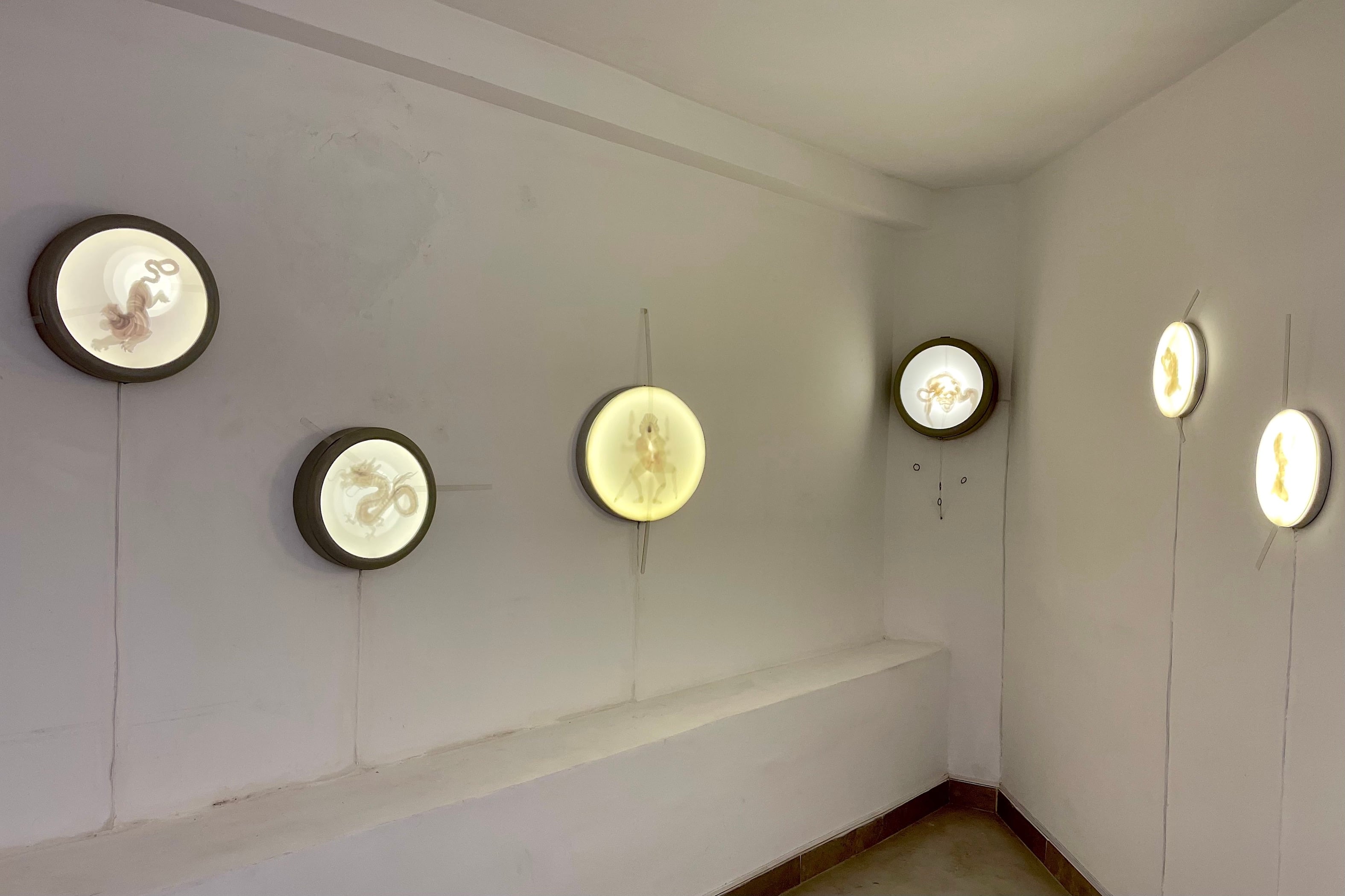 Figuras móviles en cajas de luz, de Sergio Lamanna, como ojos de buey en la "proa" del subsuelo de la galería. Abajo: Obra de Luis Rodríguez realizada con fragmentos de espejos en encastres perfectos.