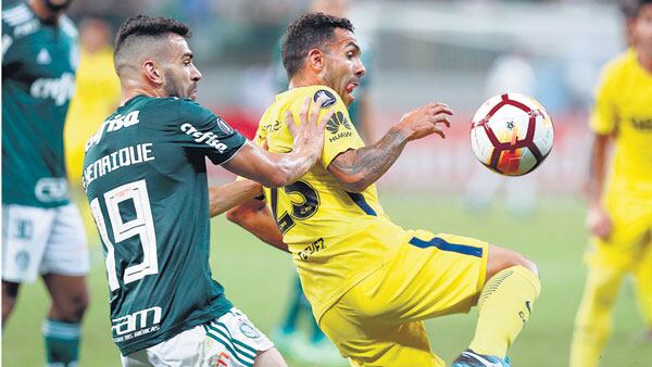 Tevez, que ingresó a los 70 minutos por Cardona, aguanta la pelota frente a la presión de Henrique.