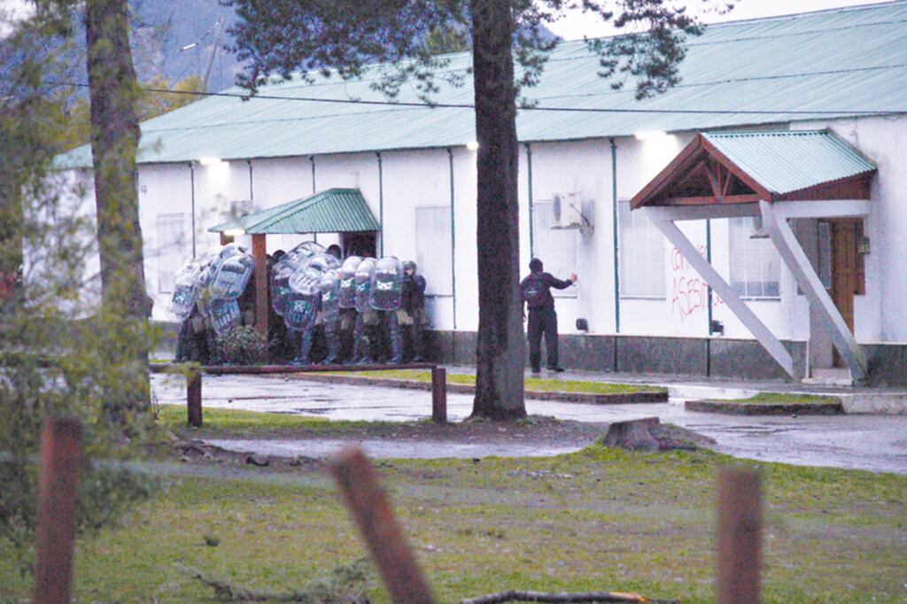 El “manifestante” pinta las paredes del Escuadrón de Gendarmería ante el indiferente pelotón de gendarmes.