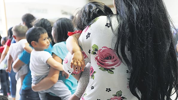 Mujeres y niños migrantes llegan a una estación de ómnibus tras ser liberados de un centro de detención en McAllen, Texas.