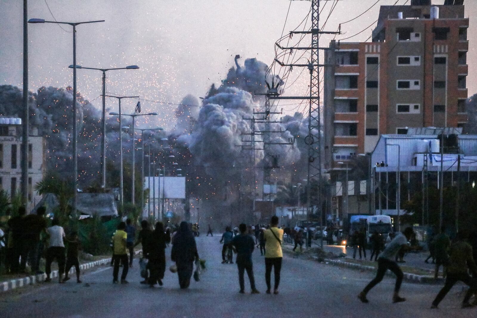 Palestinos observan el humo que se eleva tras un ataque aéreo israelí en Deir al Balah