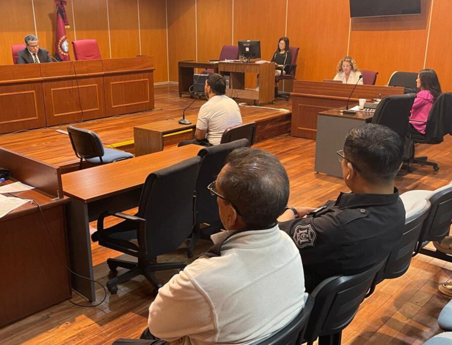 El acusado de 66 años, al lado del policía.