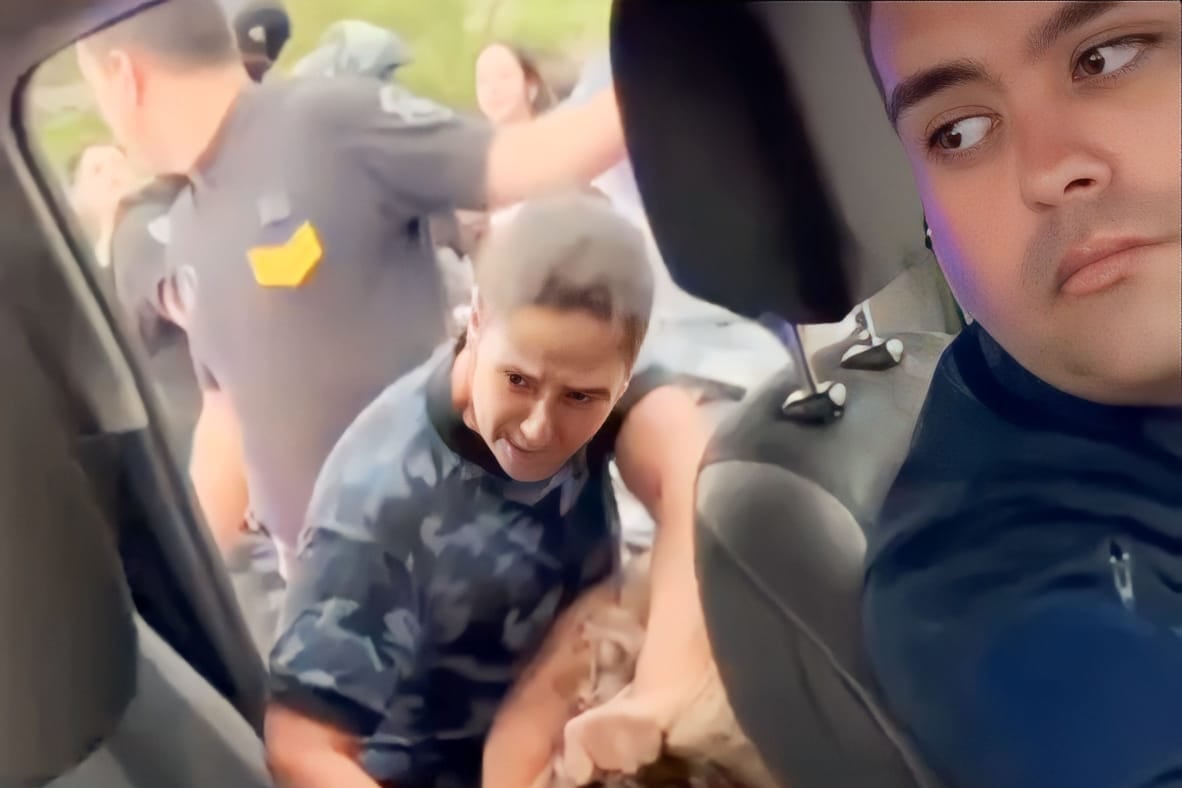 La agente policial entrando de los pelos a la joven al móvil.