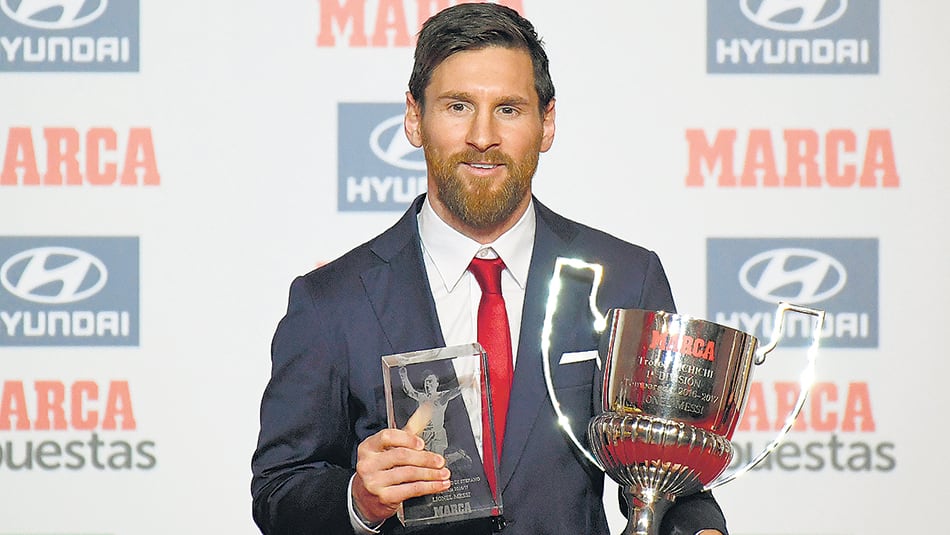Messi con los dos trofeos que ayer se llevó a su casa. “Quiero dedicarlos al vestuario” dijo.