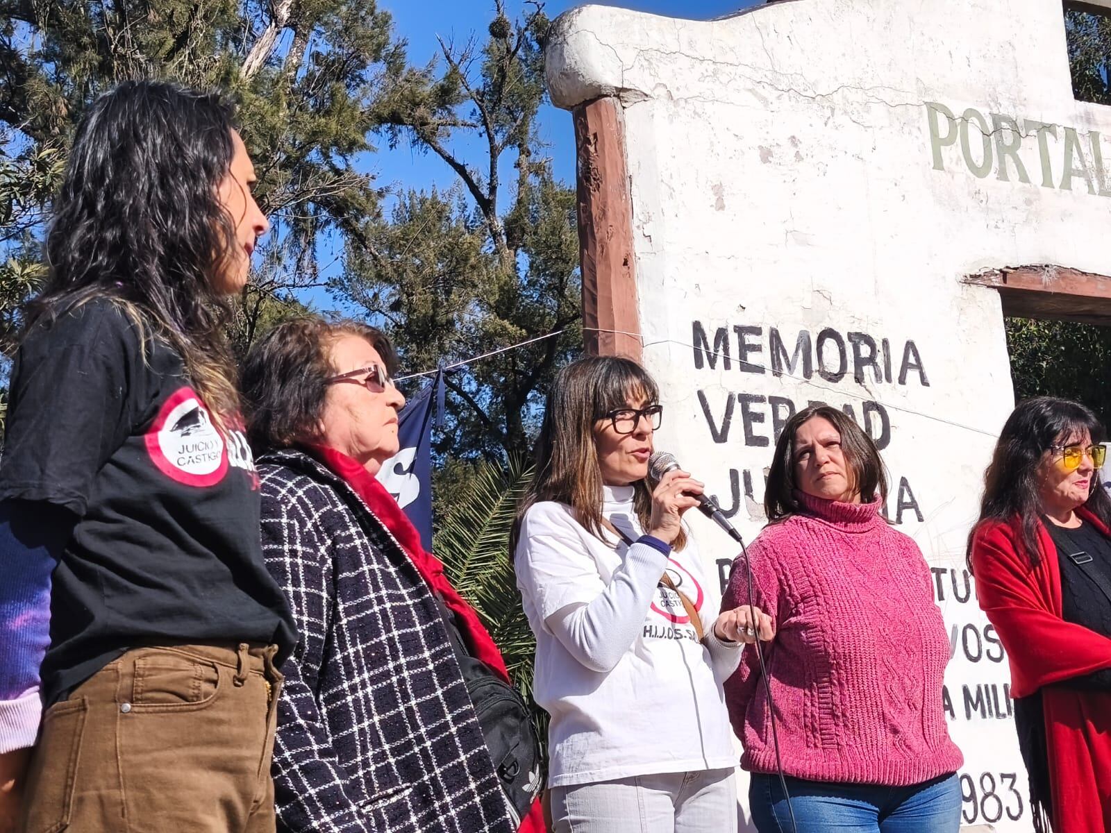 Canela Alvarez, Mariana Gamboa (al micrófono) y Elia Fernández, de HIJOS, acompañadas por Elena Rivero y Nenina Lescano
