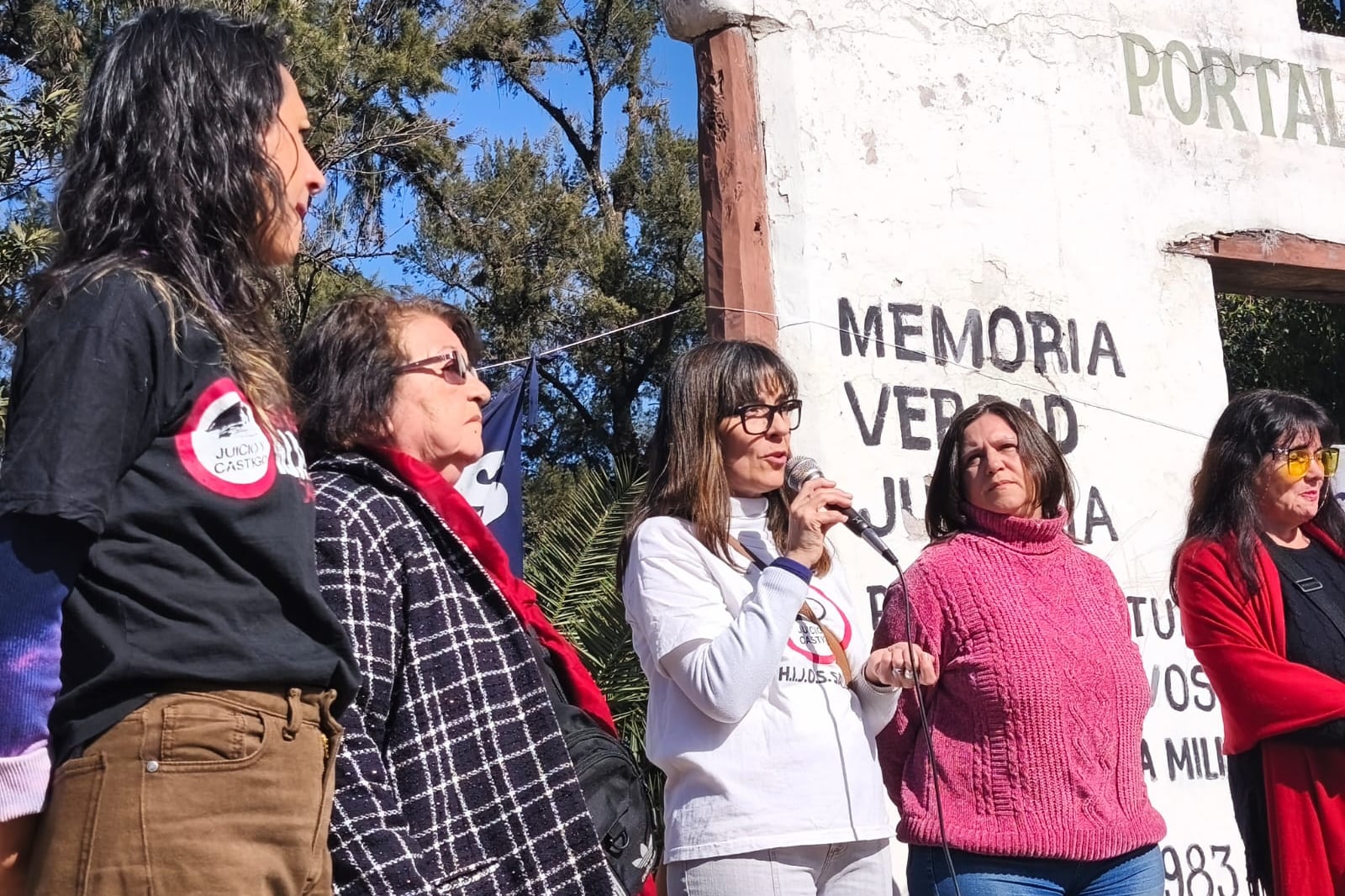Canela Alvarez, Mariana Gamboa (al micrófono) y Elia Fernández, de HIJOS, acompañadas por Elena Rivero y Nenina Lescano