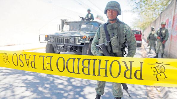 Soldados mexicanos resguardan el sitio en el que aparecieron 28 cuerpos el domingo en Guadalajara.