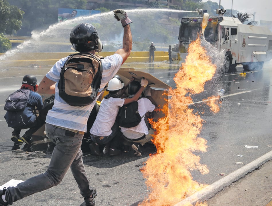 Manifestantes se enfrentan a la Guardia Nacional Bolivariana ayer en Caracas.