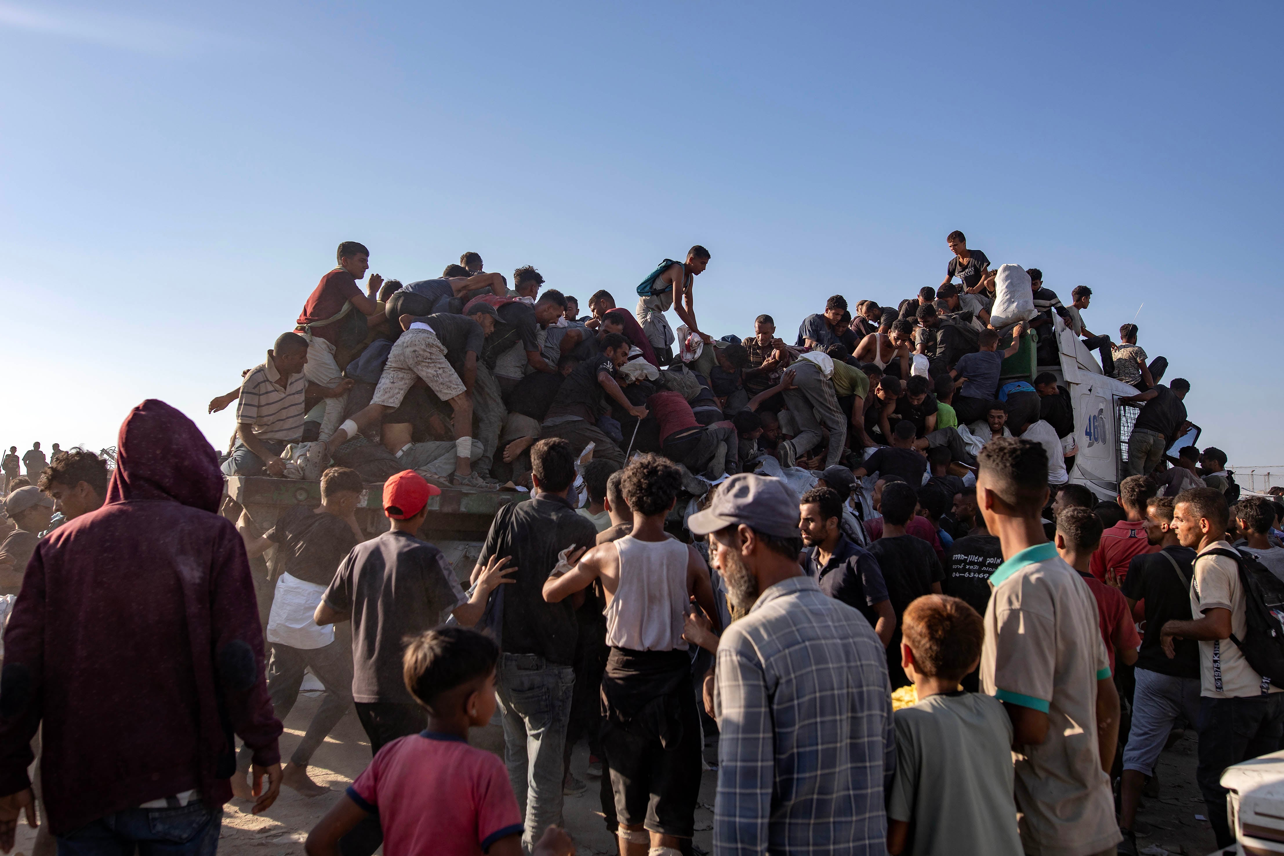 Palestinos subidos a un camión de comida en Gaza.