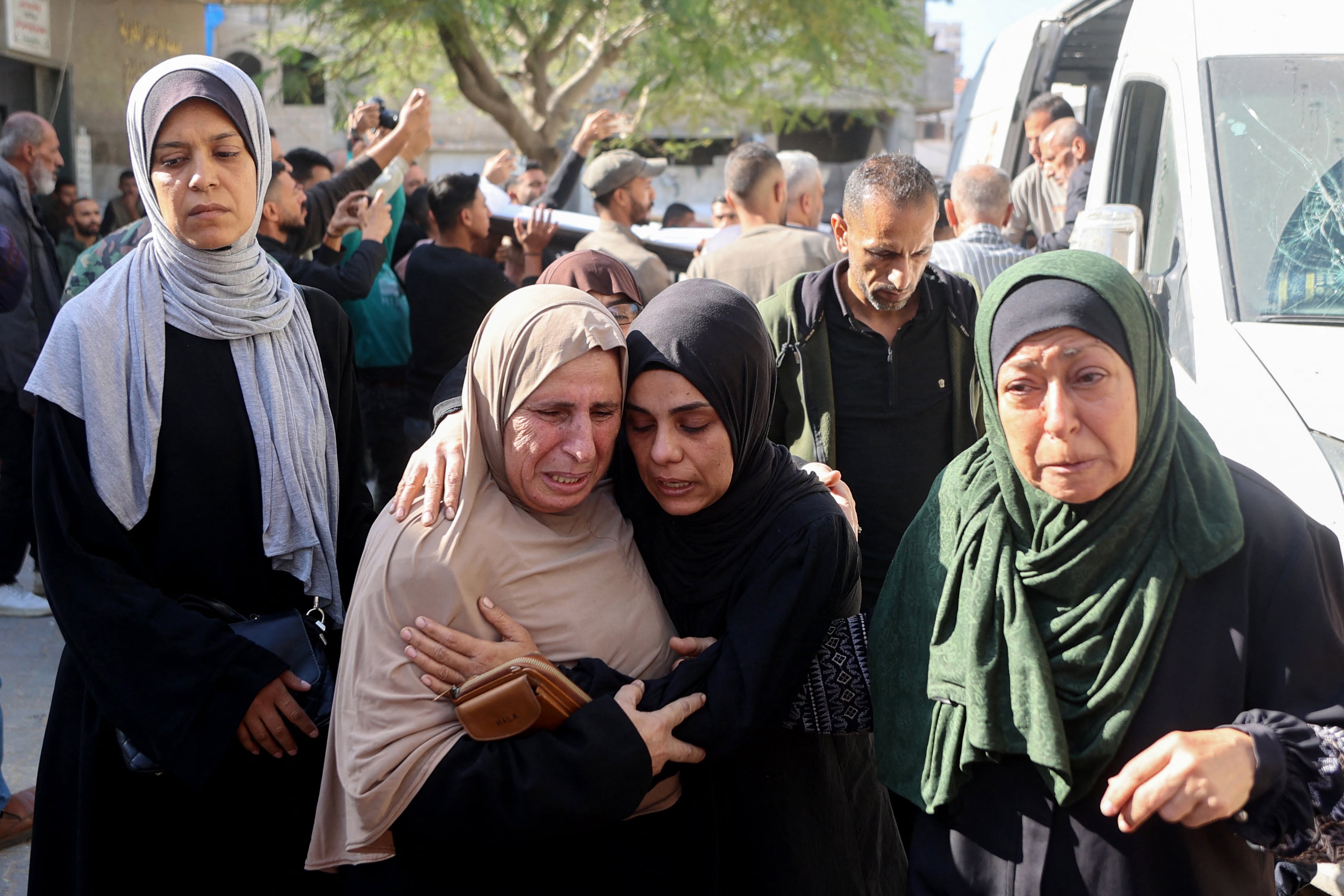Mourners reacts as they attends the funeral of Palestinians who, according to medics, were killed the day before by Israeli strikes, in Gaza City's Al-Shifa Hospital, on November 23, 2025. Gaza's civil defence agency said 21 people were killed and dozens more wounded in multiple Israeli air strikes on November 22, 2025, as Hamas and Israel again traded allegations of violating the fragile ceasefire. (Photo by Omar AL-QATTAA / AFP)