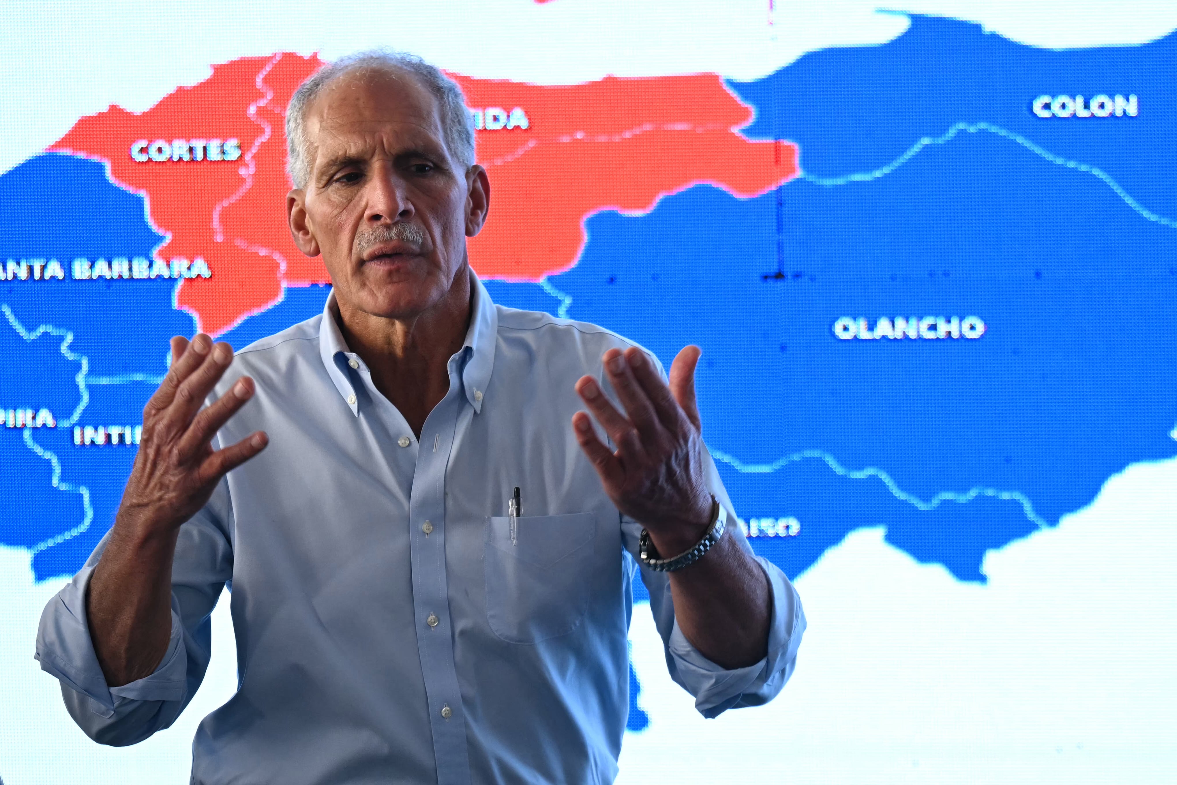Honduras' presidential candidate of the National Party Nasry Asfura speaks in front of a screen projecting a map of Honduras during a press conference in Tegucigalpa on December 1, 2025, a day after the presidential election. Candidate Nasry Asfura, supported by US President Donald Trump, and his rival Salvador Nasralla, also from the right-wing, are locked in a close race for victory in Honduras' presidential elections on Monday. (Photo by Marvin RECINOS / AFP)