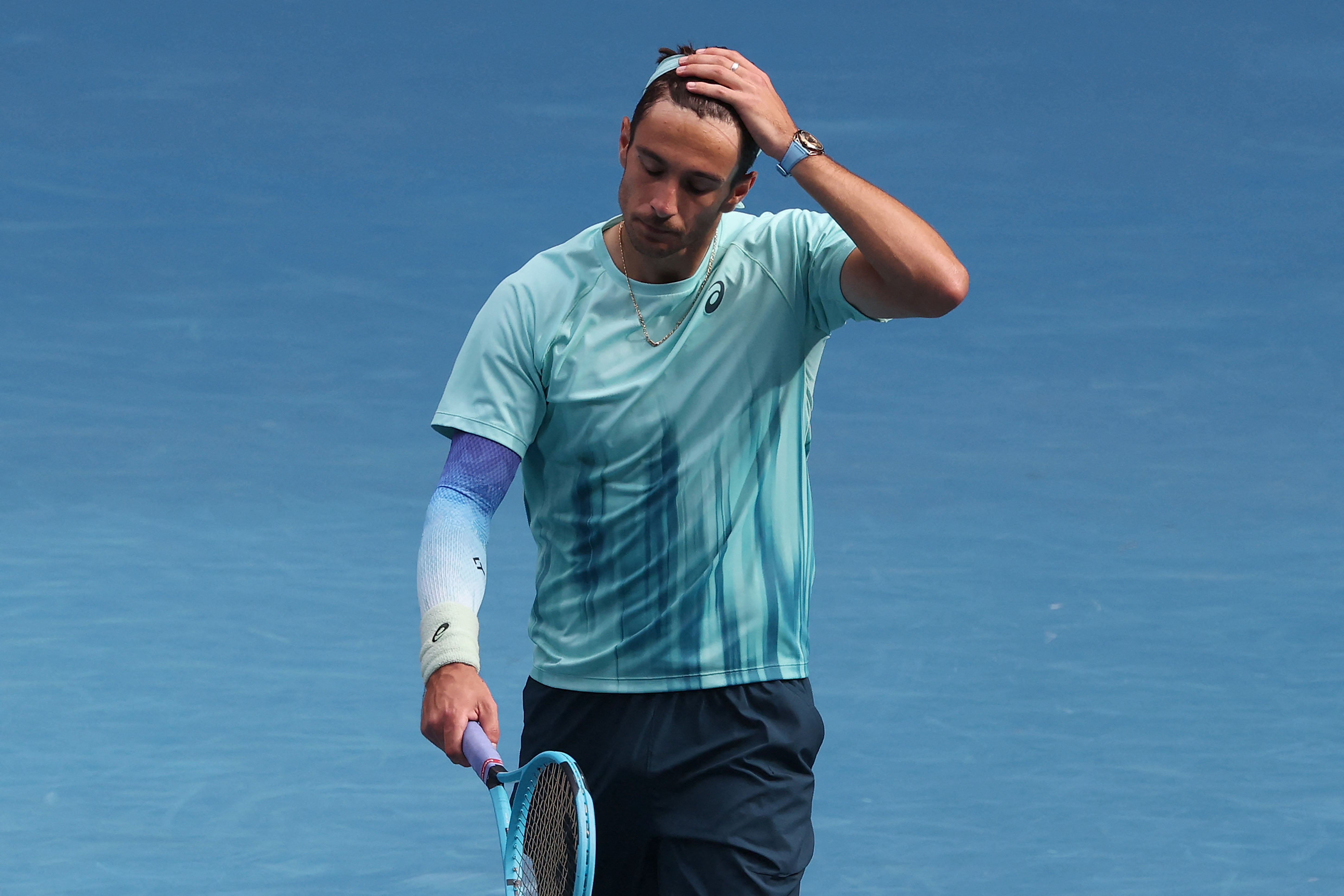 Italy's Lorenzo Musetti walks off the court after retiring injured during his men's singles quarter-final match against Serbia's Novak Djokovic on day eleven of the Australian Open tennis tournament in Melbourne on January 28, 2026. (Photo by DAVID GRAY / AFP) / -- IMAGE RESTRICTED TO EDITORIAL USE - STRICTLY NO COMMERCIAL USE --