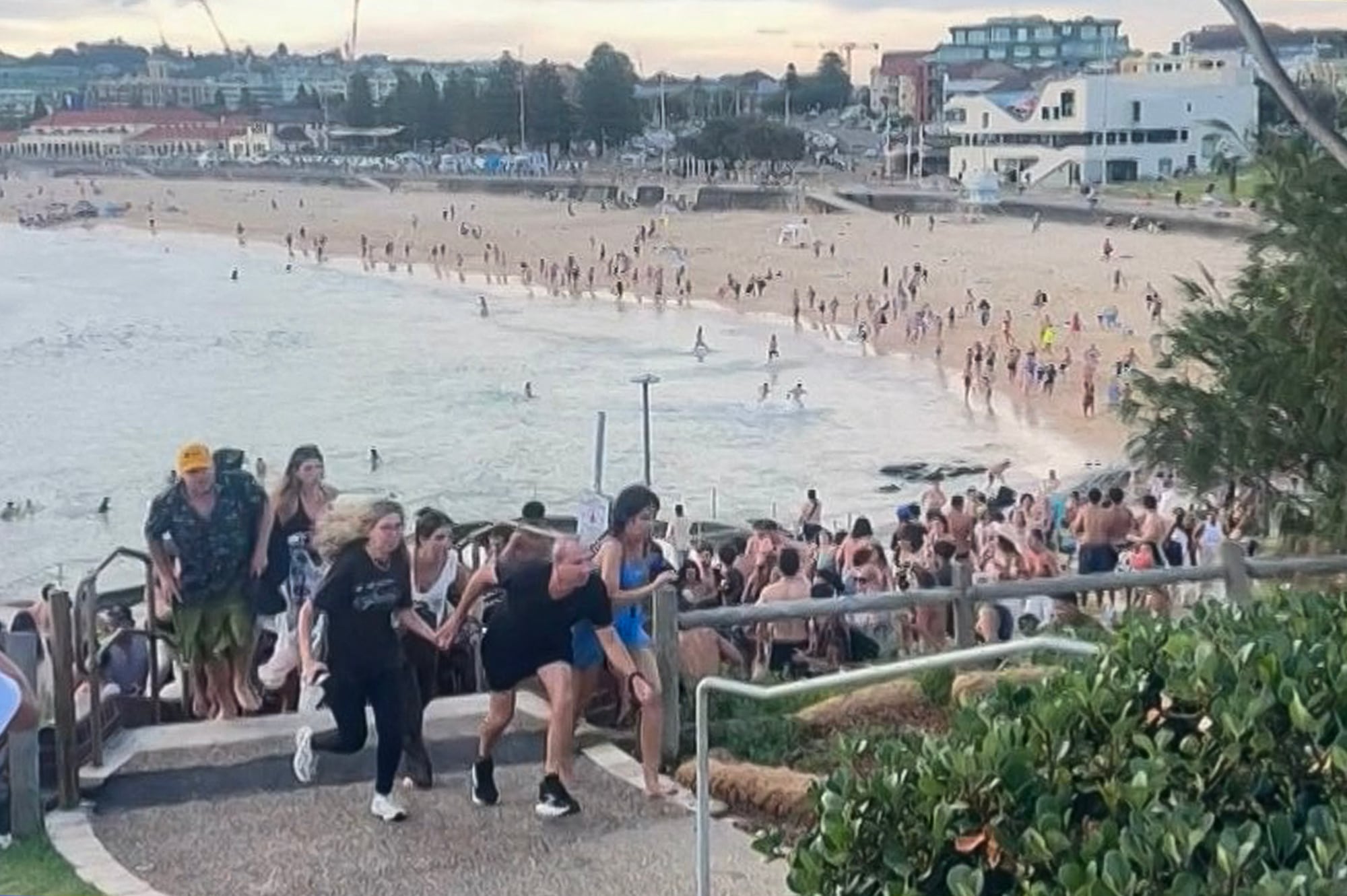 This screen grab of UGC video taken on December 14, 2025 and received courtesy of Mike Ortiz shows beach-goers fleeing Bondi Beach after gunmen opened fire, in Sydney on December 14, 2025. Two suspected shooters opened fire at Sydney's iconic Bondi Beach, killing nine people and wounding multiple others in an attack that spread panic, with bodies reported lying on the ground. (Photo by Mike Ortiz / UGC / AFP) / NO USE AFTER DECEMBER 24, 2025 10:52:26 GMT - NO USE AFTER DECEMBER 24, 2025 10:52:26 GMT - RESTRICTED TO EDITORIAL USE � MANDATORY CREDIT �  AFP PHOTO / UGC / MIKE ORTIZ � - NO MARKETING NO ADVERTISING CAMPAIGNS � DISTRIBUTED AS A SERVICE TO CLIENTS [ NO ARCHIVE ] /