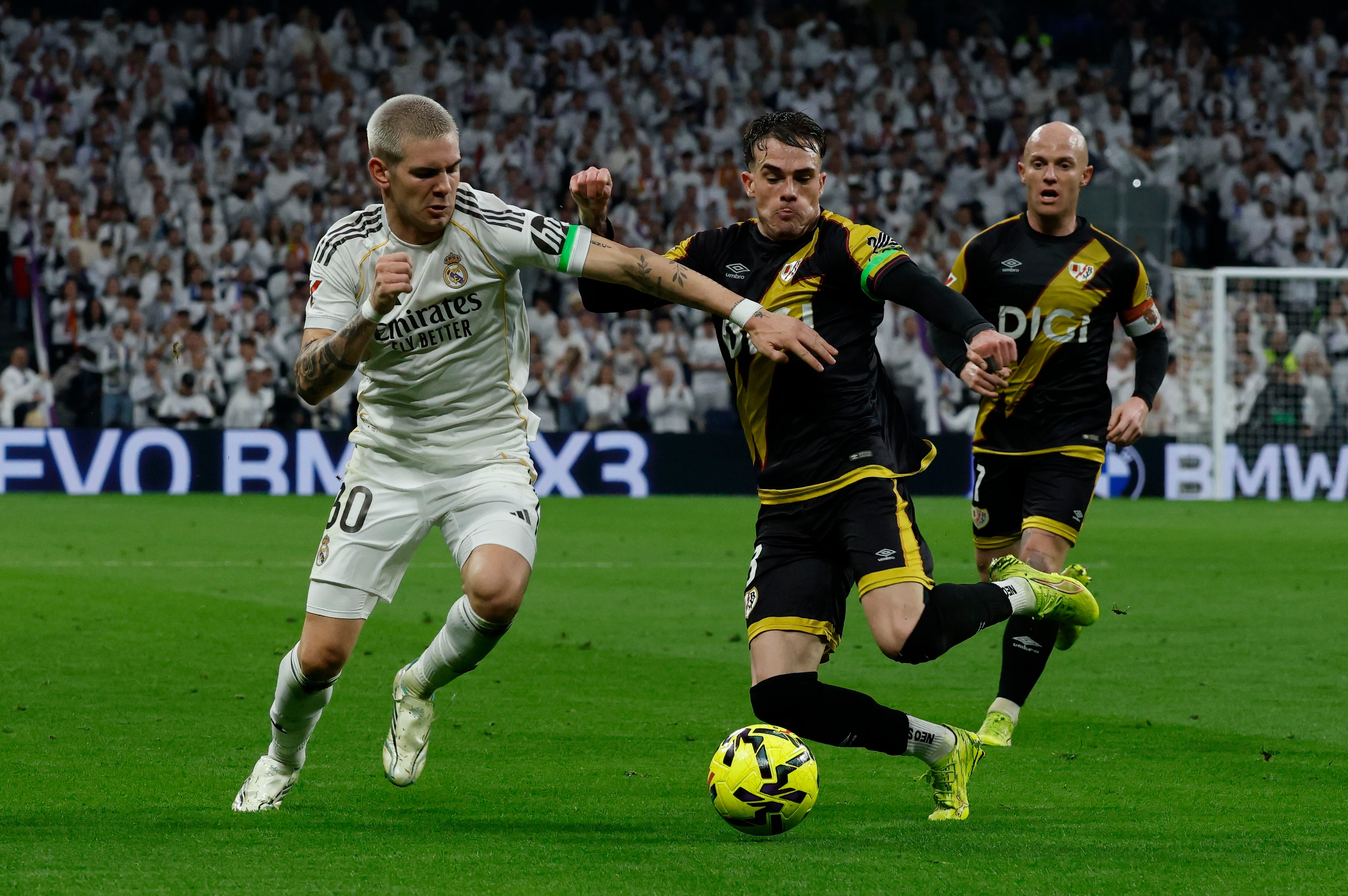 MADRID, 01/02/2026.- El centrocampista del Real Madrid Franco Mastantuono (i) disputa la posesión del balón con el defensa del Rayo Vallecano Pep Chavarría (c) durante el partido de LaLiga que enfrenta al Real Madrid y al Rayo Vallecano, este domingo, en el Santiago Bernabéu. EFE/ J.J. Guillén
