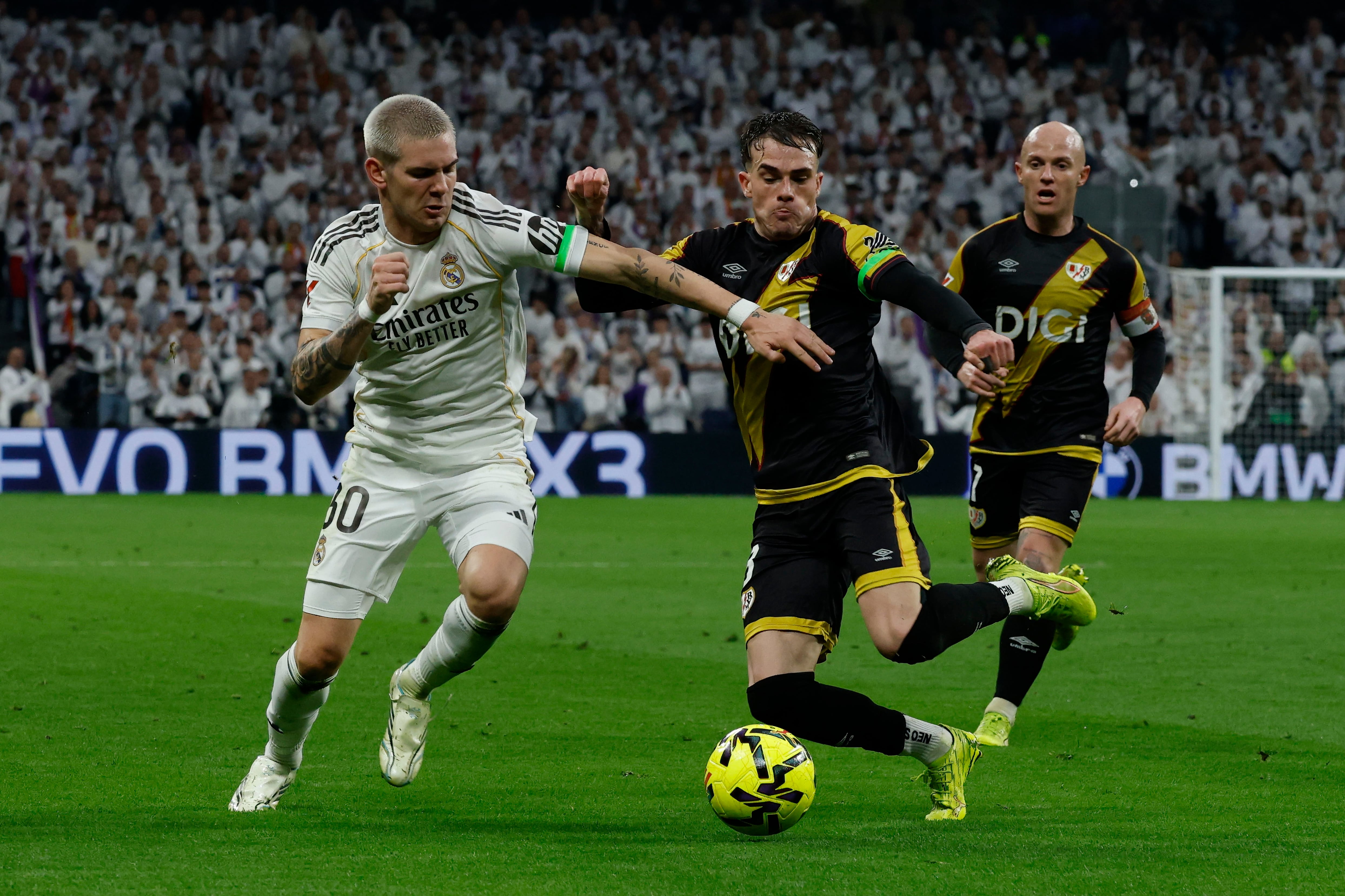 MADRID, 01/02/2026.- El centrocampista del Real Madrid Franco Mastantuono (i) disputa la posesión del balón con el defensa del Rayo Vallecano Pep Chavarría (c) durante el partido de LaLiga que enfrenta al Real Madrid y al Rayo Vallecano, este domingo, en el Santiago Bernabéu. EFE/ J.J. Guillén