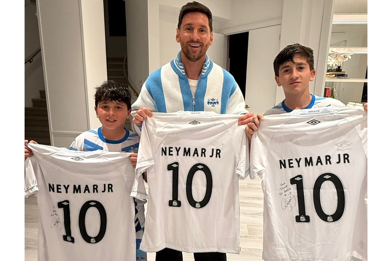 Lionel Messi junto a sus hijos Thiago y Mateo, con camiseras obsequiadas por Neymar Jr