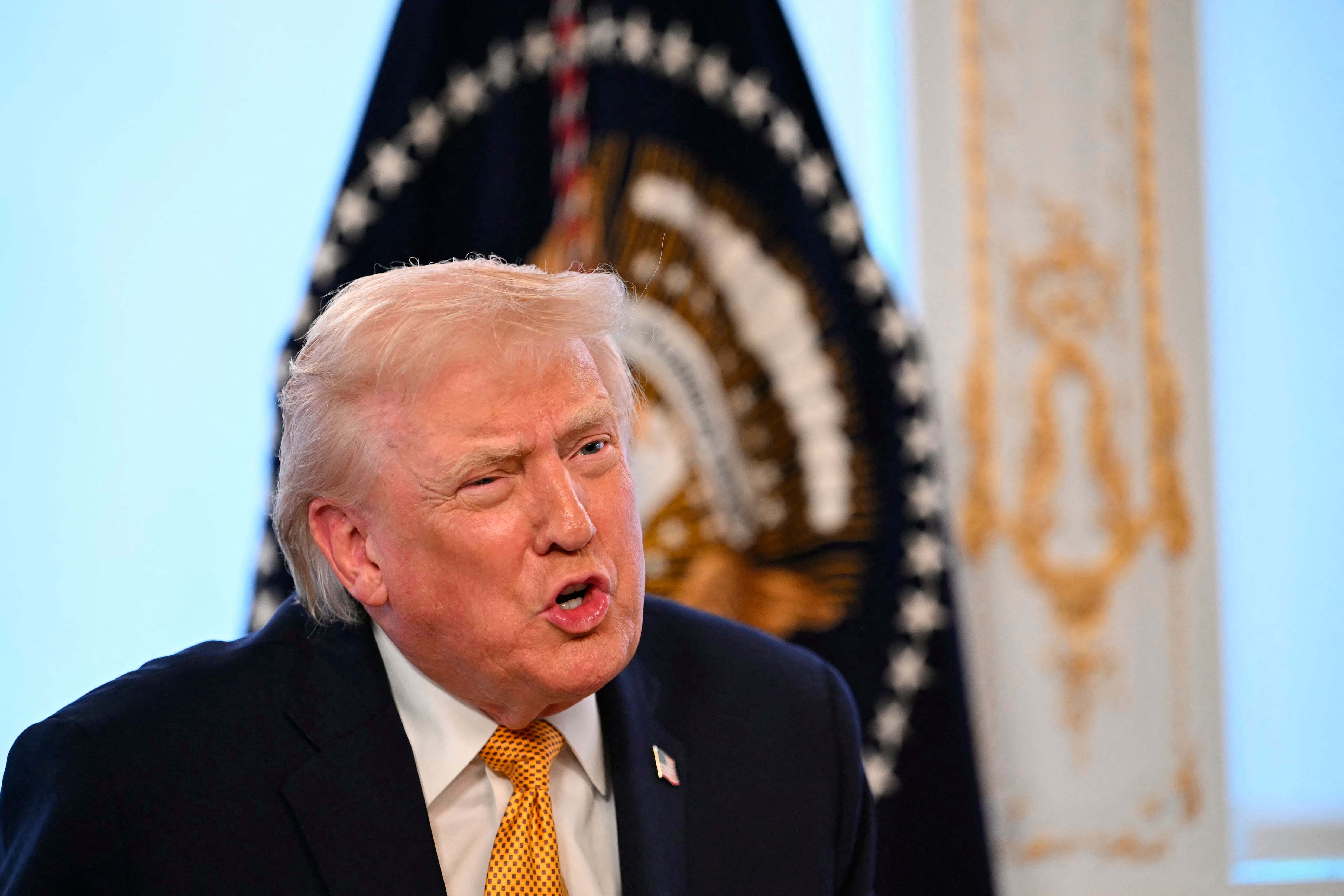 US President Donald Trump participates in calls to US service members, on Christmas Eve, from the Mar-a-Lago club in Palm Beach, Florida, December 24, 2025. (Photo by ANDREW CABALLERO-REYNOLDS / AFP)