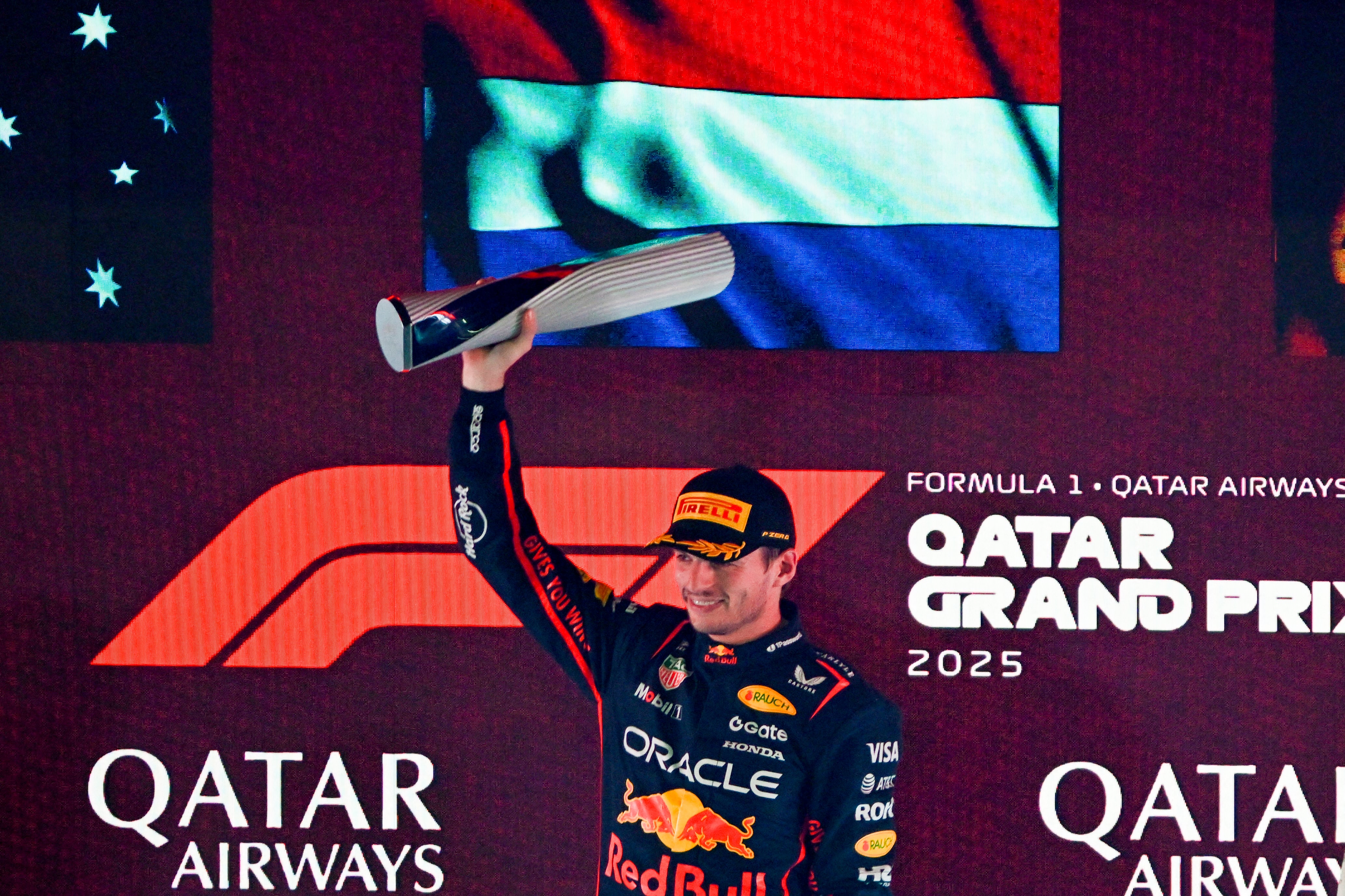 Red Bull Racing's Dutch driver Max Verstappen celebrates with the winning trophy at the end of the Formula One Qatar Grand Prix at the Lusail International Circuit in Lusail on November 30, 2025. (Photo by Mahmud HAMS / AFP)