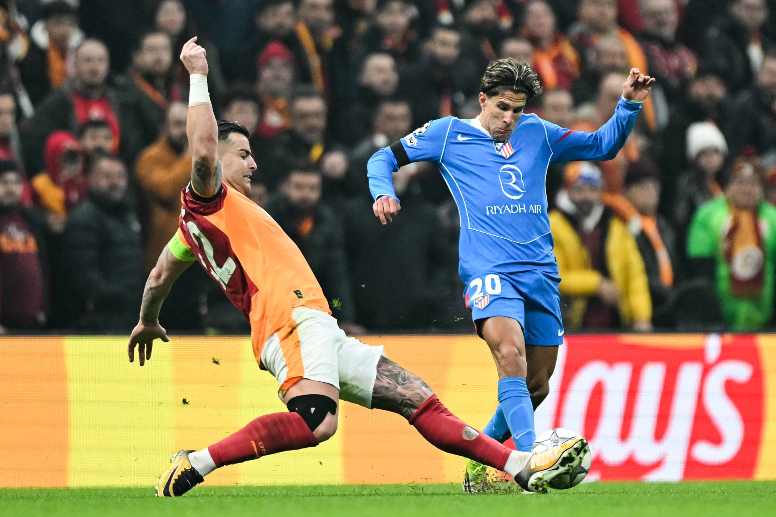 Galatasaray's Turkish defender #42 Abdulkerim Bardakci (L) fights for the ball with Atletico Madrid's Argentine forward #20 Giuliano Simeone during the UEFA Champions League, league phase day 7, football match between Galatasaray and Atletico Madrid at Rams Park in Istanbul, on January 21, 2026. (Photo by OZAN KOSE / AFP)