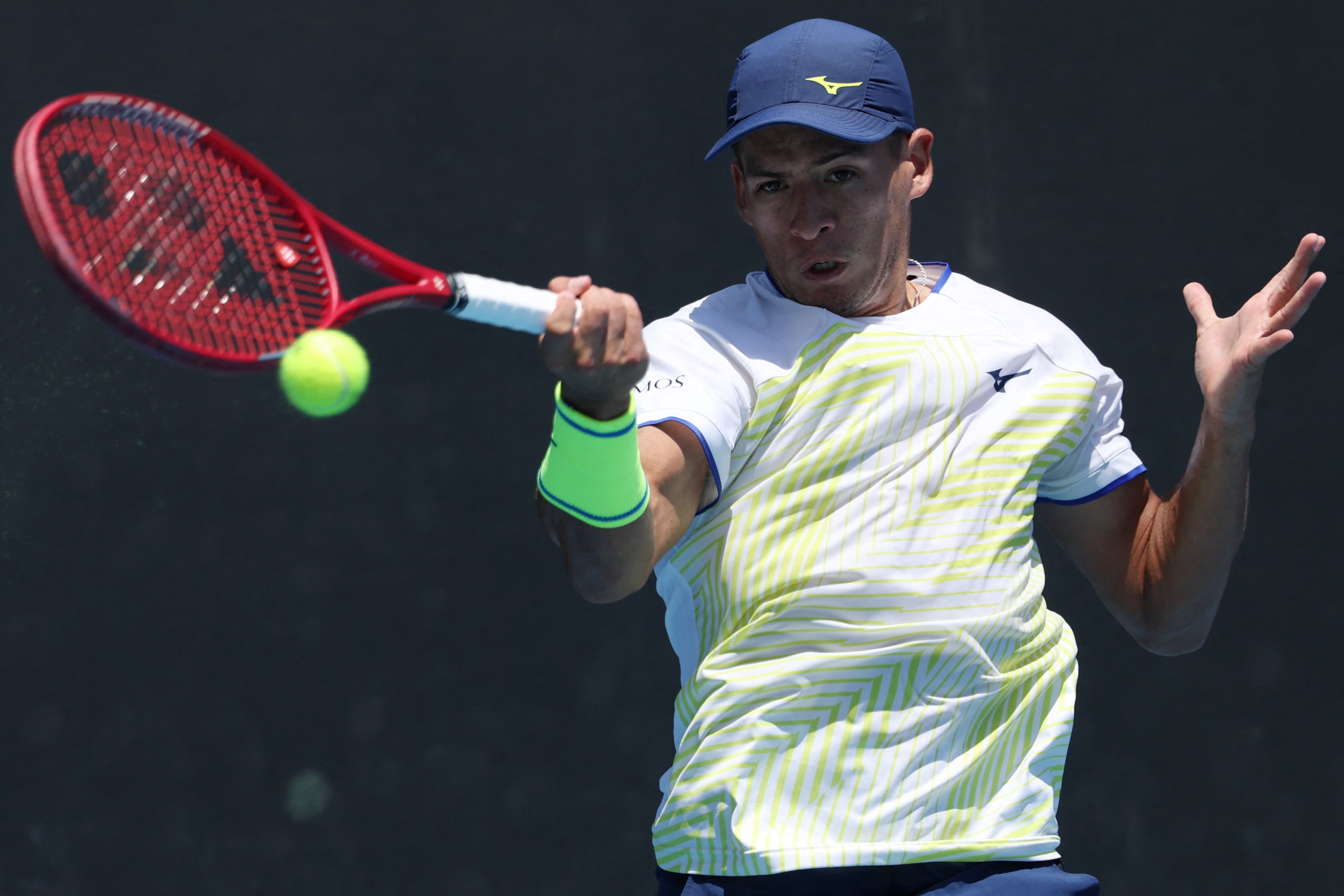 Argentina�s Sebastian Baez hits a return against France�s Giovanni Mpetshi Perricard during their men's singles match on day three of the Australian Open tennis tournament in Melbourne on January 20, 2026. (Photo by IZHAR KHAN / AFP) / -- IMAGE RESTRICTED TO EDITORIAL USE - STRICTLY NO COMMERCIAL USE --