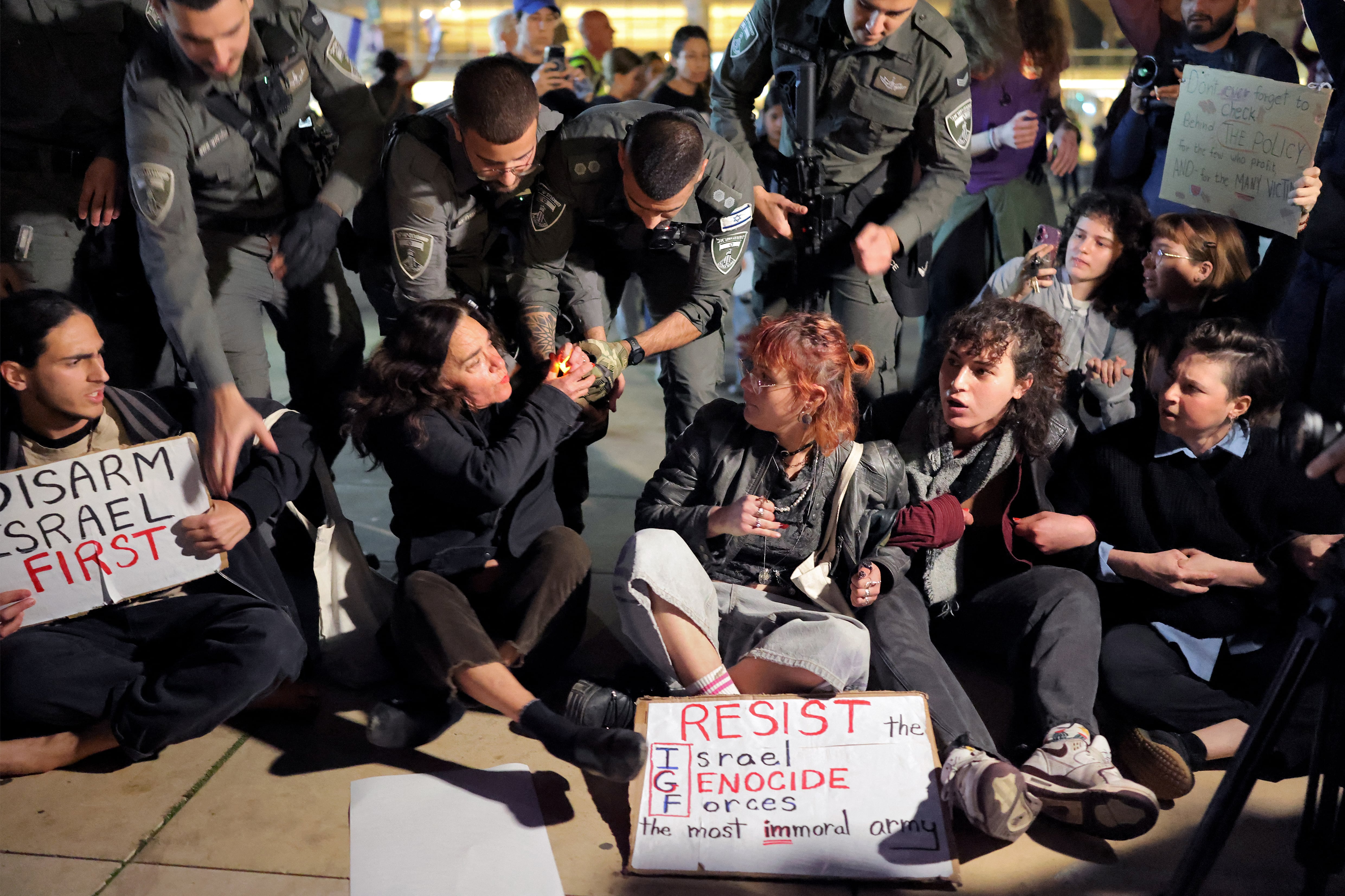 Israeli border guards attempt to remove protesters from the weekly anti-war demonstration at HaBima Square in Tel Aviv on March 28, 2026 amid safety concerns over possible projectile attacks. The US and Israel launched strikes against Iran on February 28, sparking swift retaliation by the Islamic republic which responded with missile attacks across the region. (Photo by Ilia YEFIMOVICH / AFP)