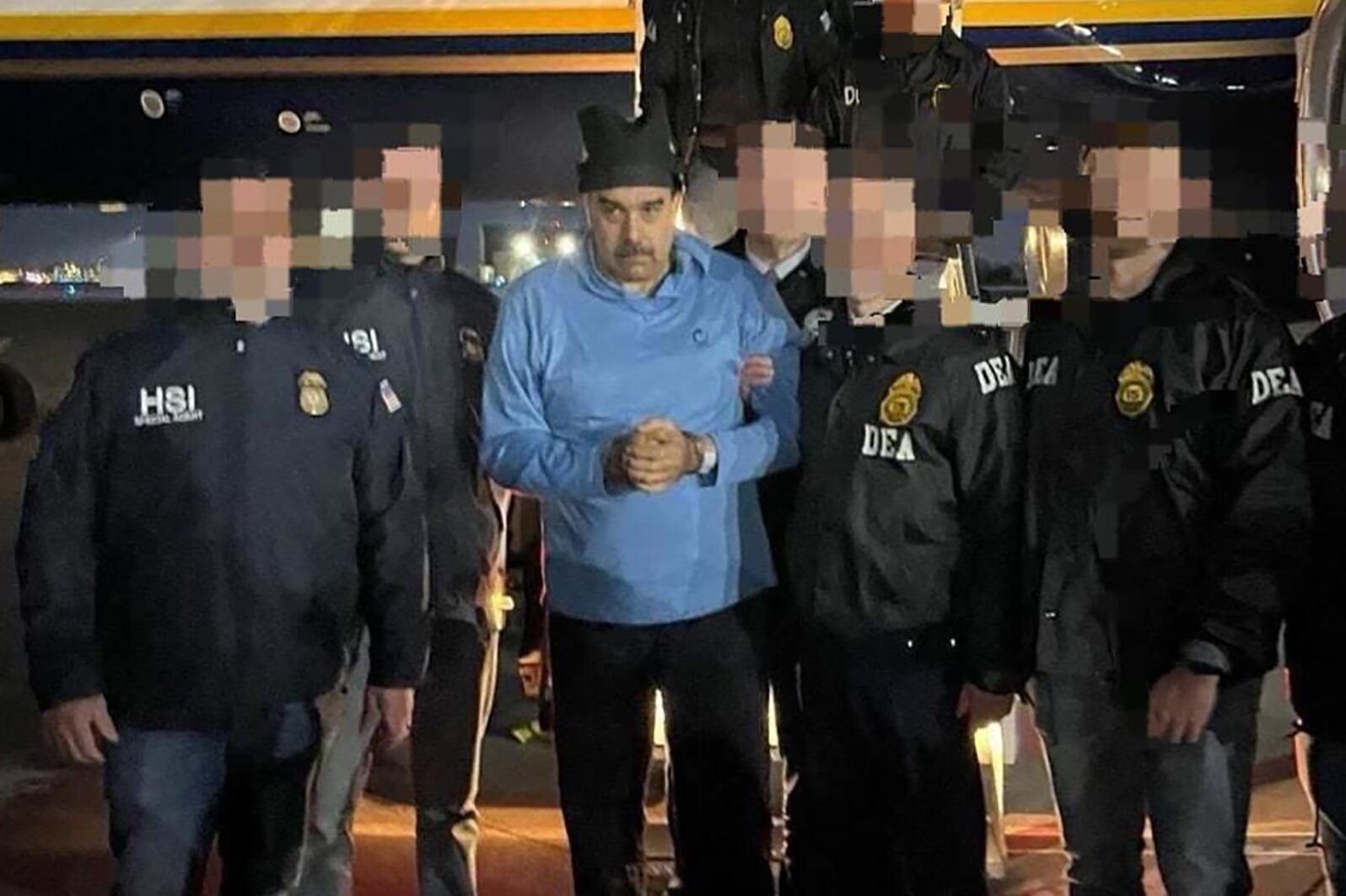 AME2046. NUEVA YORK (ESTADOS UNIDOS), 03/01/2026.- Fotografía que muestra al presidente de Venezuela, Nicolás Maduro (c), escoltado por agentes de la Administración para el Control de Drogas (DEA), luego de su captura, este sábado en Nueva York (Estados Unidos). La captura de Maduro por parte de Estados Unidos sumió al país suramericano en la incertidumbre después del anuncio del mandatario Donald Trump de que gobernarán esta nación, mientras la oposición mayoritaria llamó los ciudadanos a estar vigilantes hasta que se «concrete la transición». EFE/ Rastreo de Redes /SOLO USO EDITORIAL/ NO VENTAS/ SOLO DISPONIBLE PARA ILUSTRAR LA NOTICIA QUE ACOMPAÑA (CRÉDITO OBLIGATORIO)