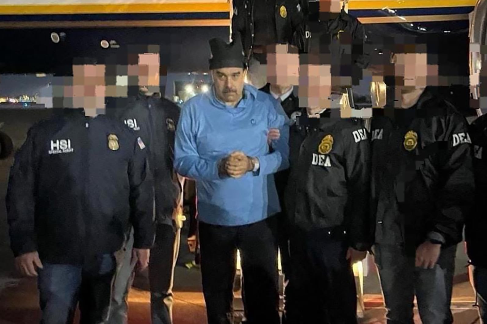 AME2046. NUEVA YORK (ESTADOS UNIDOS), 03/01/2026.- Fotografía que muestra al presidente de Venezuela, Nicolás Maduro (c), escoltado por agentes de la Administración para el Control de Drogas (DEA), luego de su captura, este sábado en Nueva York (Estados Unidos). La captura de Maduro por parte de Estados Unidos sumió al país suramericano en la incertidumbre después del anuncio del mandatario Donald Trump de que gobernarán esta nación, mientras la oposición mayoritaria llamó los ciudadanos a estar vigilantes hasta que se «concrete la transición». EFE/ Rastreo de Redes /SOLO USO EDITORIAL/ NO VENTAS/ SOLO DISPONIBLE PARA ILUSTRAR LA NOTICIA QUE ACOMPAÑA (CRÉDITO OBLIGATORIO)