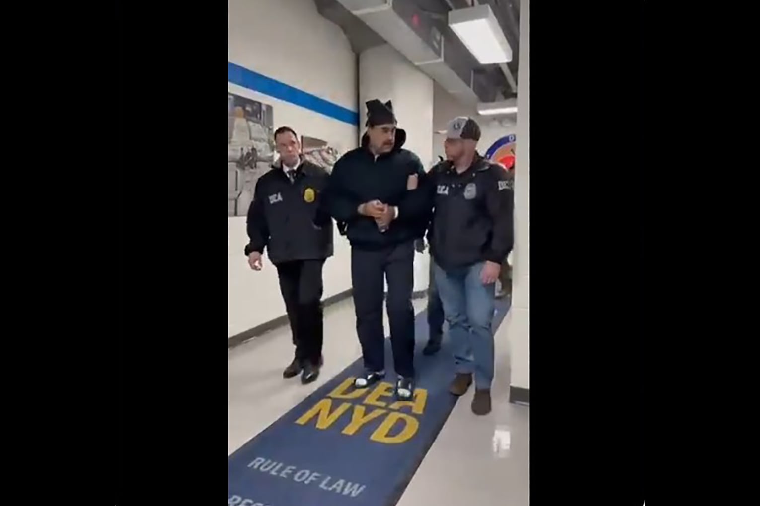 AME2043. NUEVA YORK (ESTADOS UNIDOS), 03/01/2026.- Captura de video tomada de la cuenta en X @RapidResponse47 de la Casa Blanca del presidente de Venezuela, Nicolás Maduro (c), a su llegada a la sede de la DEA este sábado, en Nueva York (EE.UU.). EFE/ Rapidresponse47 /SOLO USO EDITORIAL/ NO VENTAS/ SOLO DISPONIBLE PARA ILUSTRAR LA NOTICIA QUE ACOMPAÑA (CRÉDITO OBLIGATORIO)