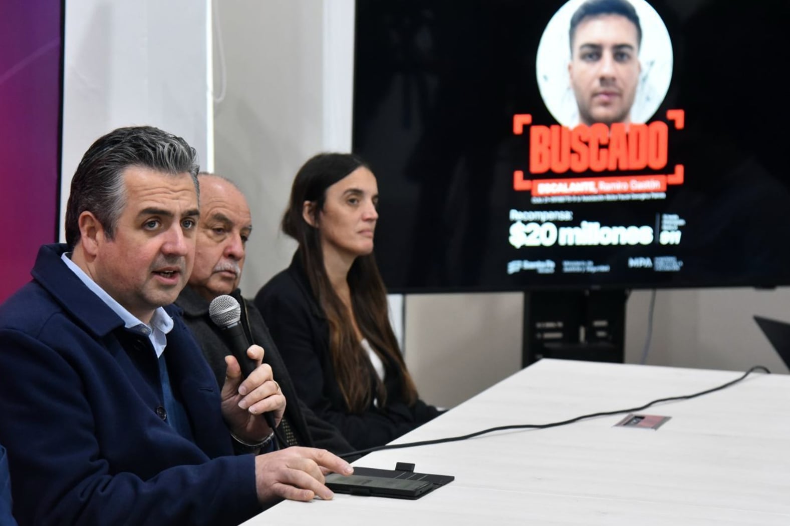 Los funcionarios de Seguridad con uno de los carteles de "buscado".