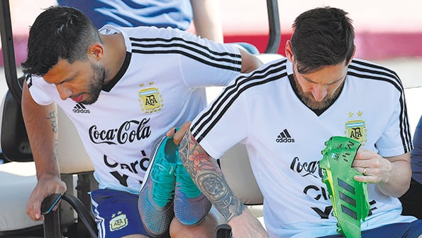 Agüero y Messi con los botines en sus manos. Preocupa el estado de ánimo del capitán argentino.