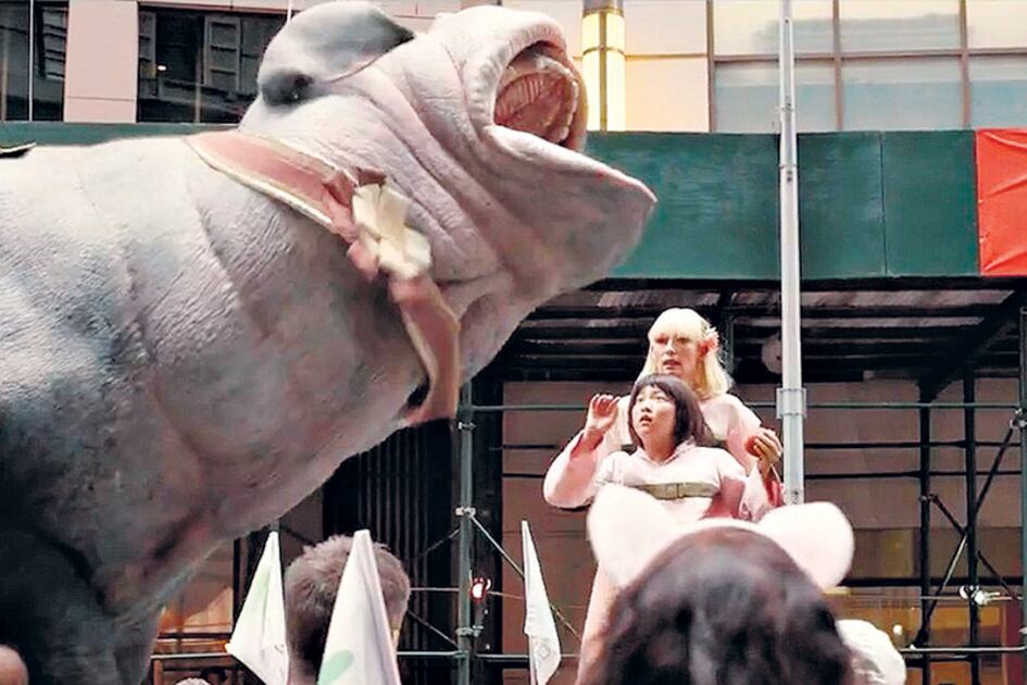 La chancha Okja, su pequeña amiga y la villana encarnada por Tilda Swinton en el clímax del film.