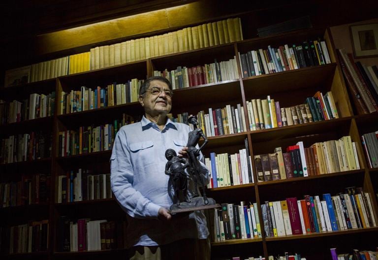 Ramírez, en su casa de Managua, junto a una estatua de Don Quijote y Sancho,tras conocer la noticia del premio.