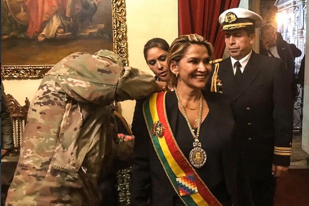 Un militar le coloca la banda presidencial a Añez, autoproclamada presidenta sin quórum en el Congreso boliviano.