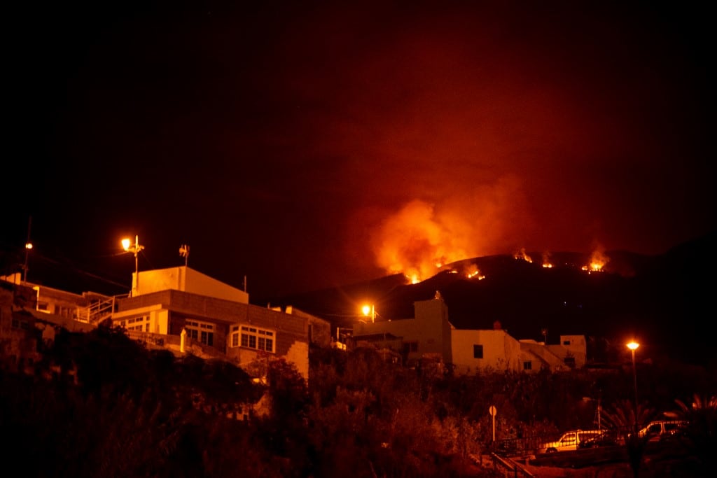 El fuego se expande en las colinas por encima de las casas, en el valle de Guimar en la isla canaria de Tenerife.