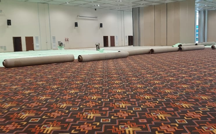 La tarea de tapar las alfombras del Centro de Convenciones 