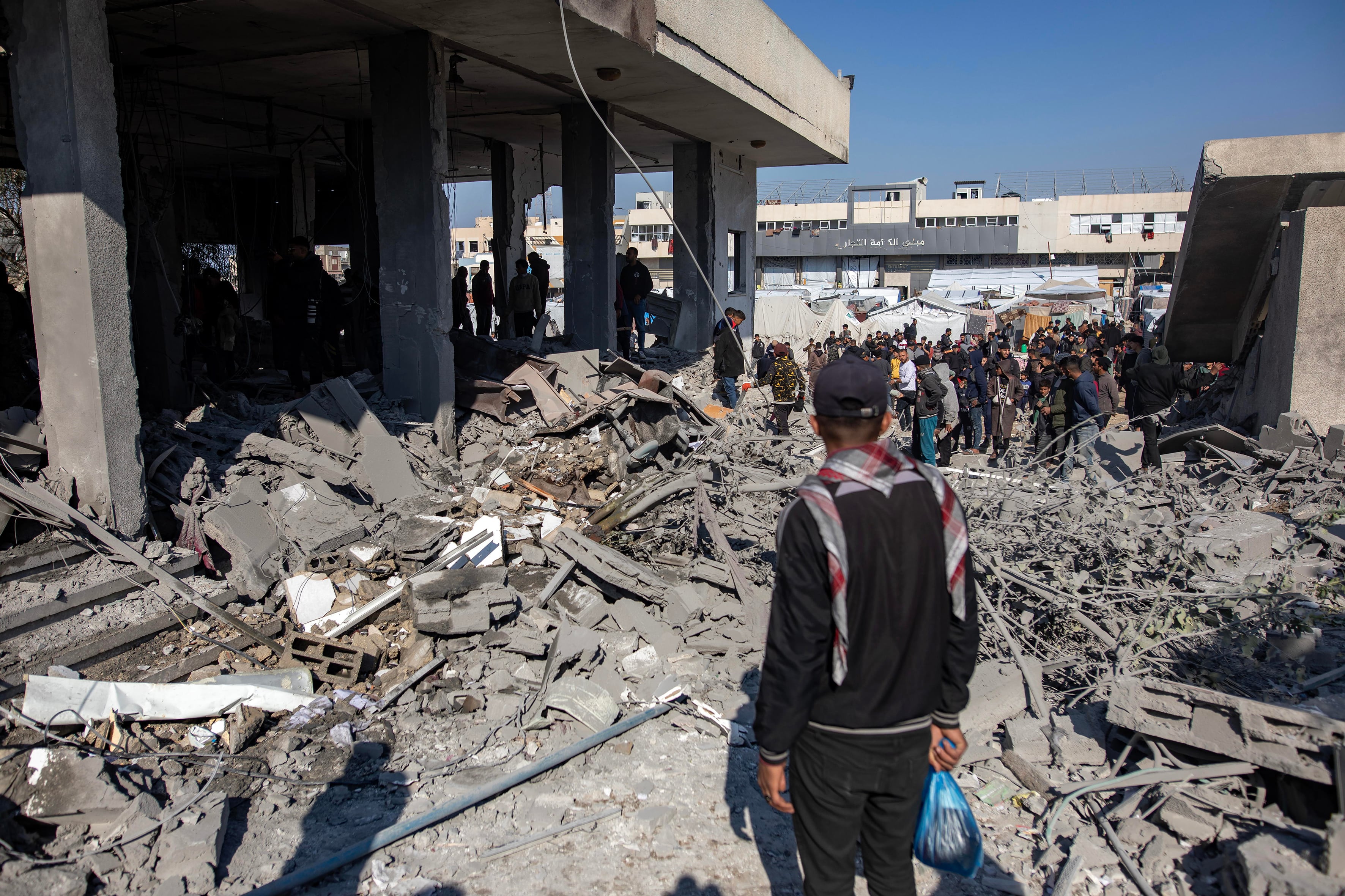 Palestinos inspeccionan el lugar de un ataque aéreo israelí en la sureña Jan Yunis