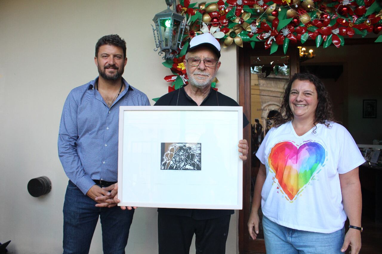 El grabado que recuerda a Norberto Torres, entregado por Diego Nanni y Sandra Conte a Gieco.