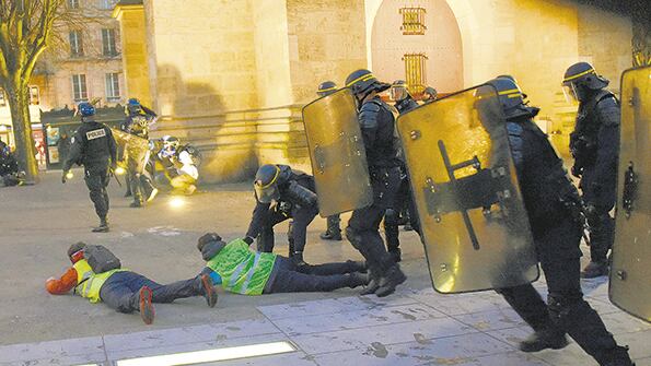 Policías antimotines detienen a manifestantes con chalecos amarillos en Bordeaux.