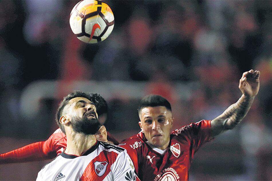 Pratto disputa la pelota con Bustos. Independiente y River igualaron sin tantos en Avellaneda.