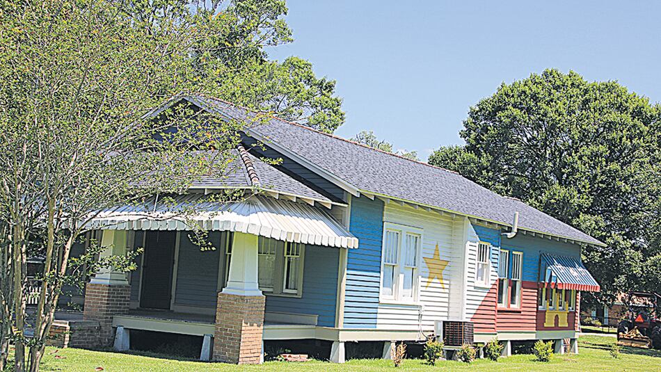 Una casa tradicional pintada con los colores de la bandera de los antiguos acadianos.