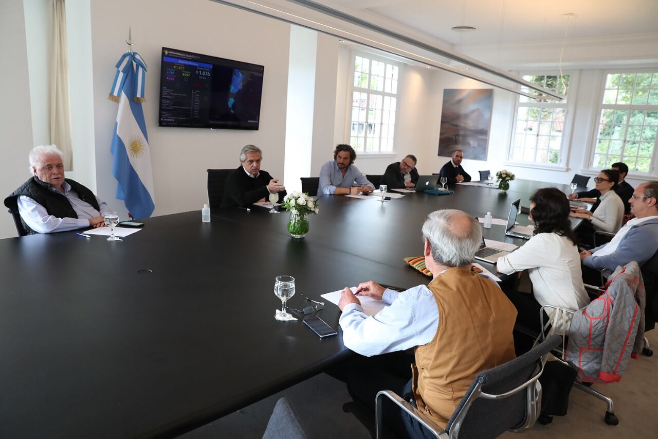 Alberto Fernández con sus funcionarios en Olivos y la pantalla con los datos de la pandemia detrás.