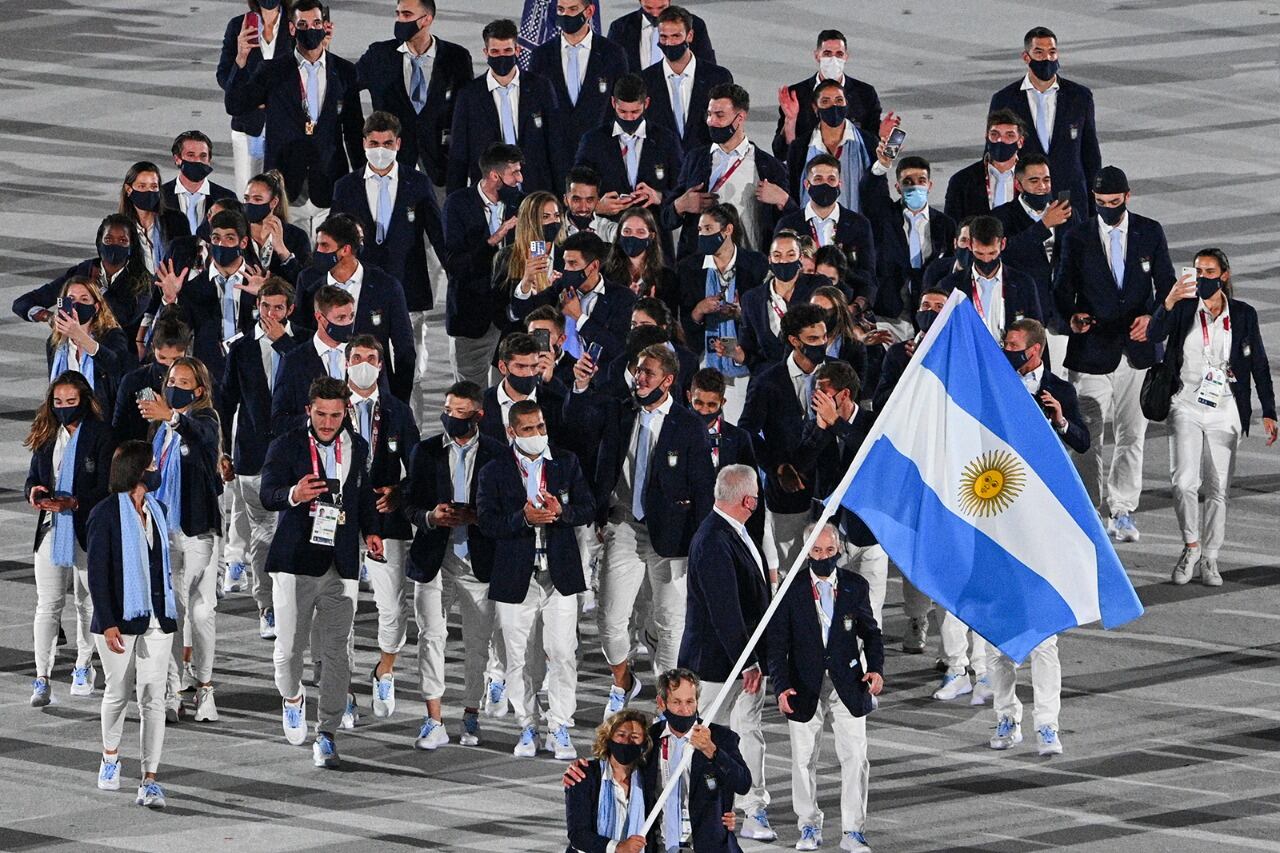 Cecilia Carranza Saroli y Santiago Lange, portan la bandera nacional.