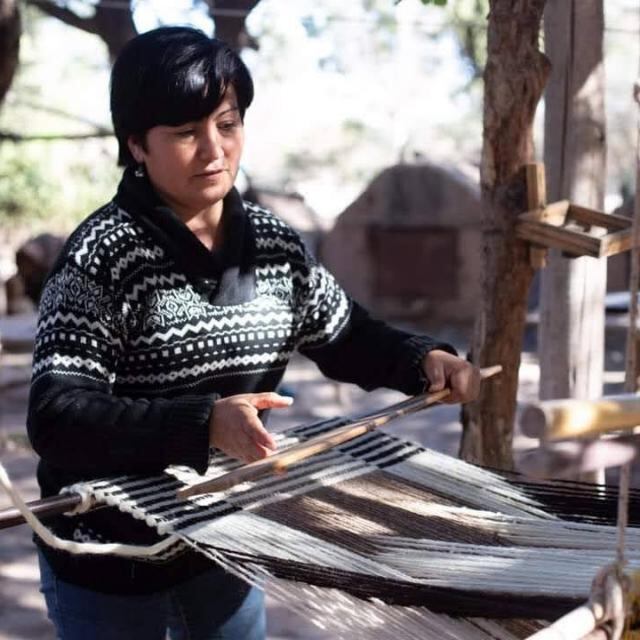 Laura, la "portera" de la comunidad, marca el tiempo de producción en su telar