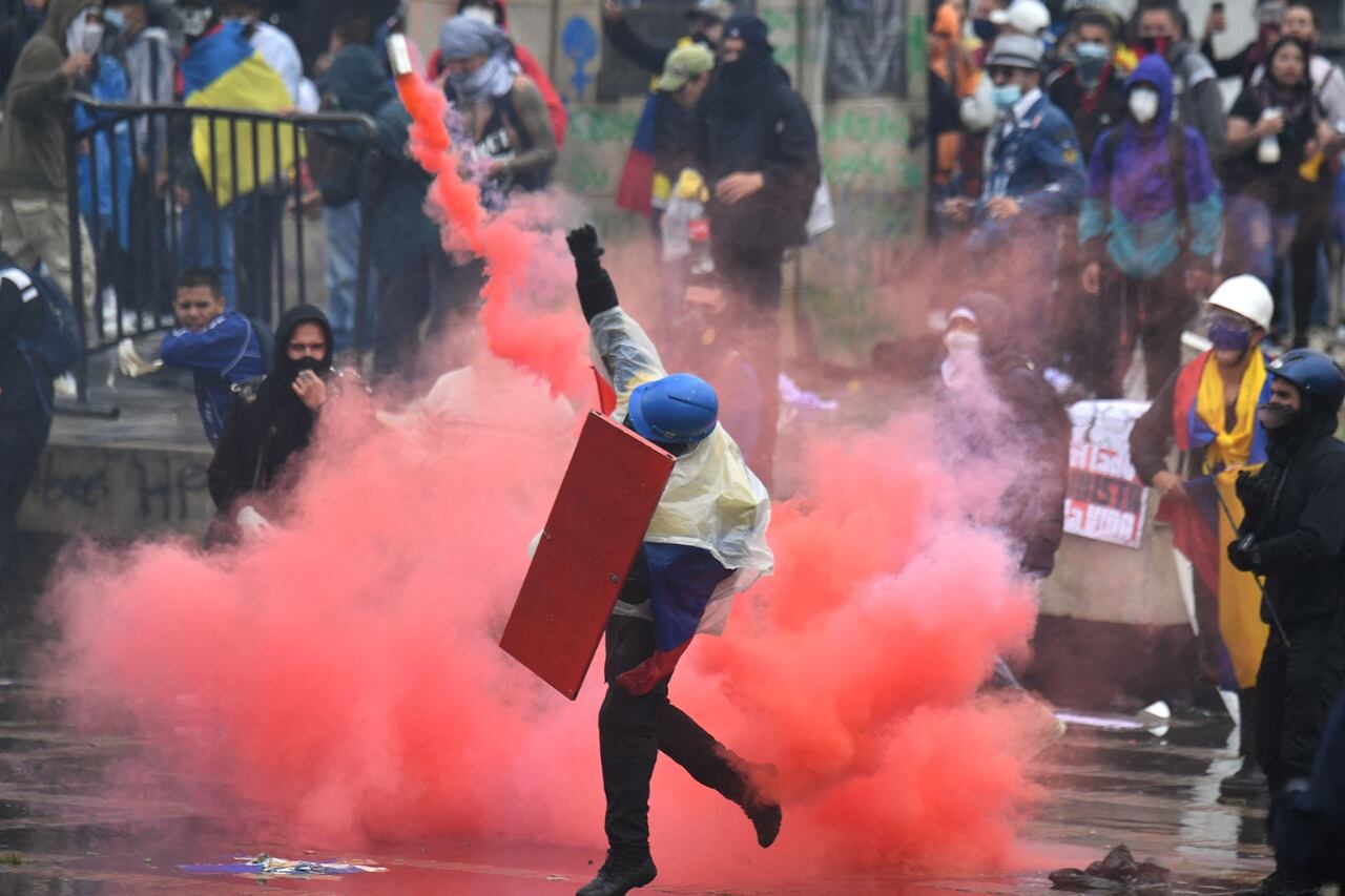 Un manifestante arroja una bomba de humo durante una protesta en Bogotá 