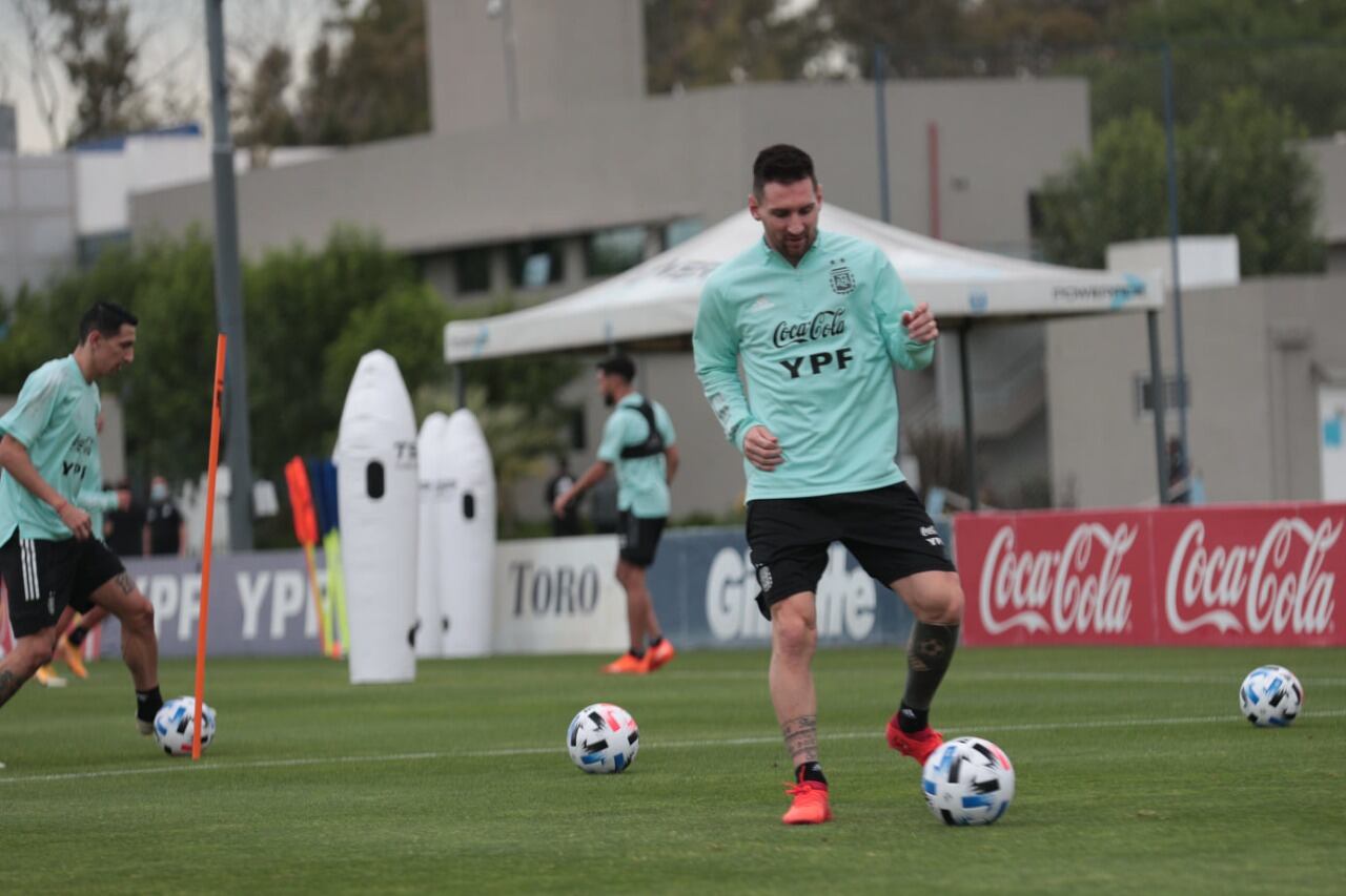 Messi, sonriente con la pelota; más atrás, Di María.