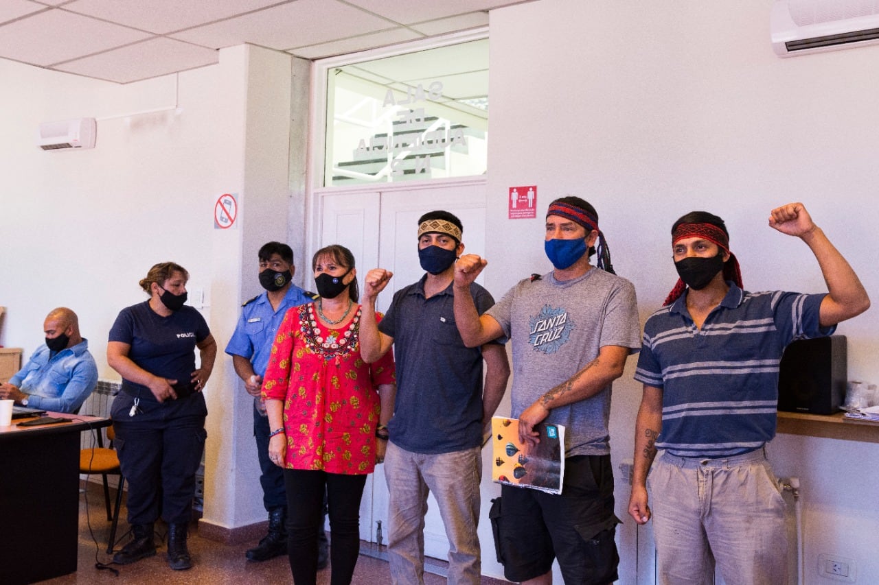 De izquierda a derecha, imputado policía Javier Solorza (sentado con barbijo negro y camisa celeste), abogada Sonia Ivanoff (de rojo), Fernando Jones Huala, Emilio Jones y Fausto Jones Huala, los querellantes.