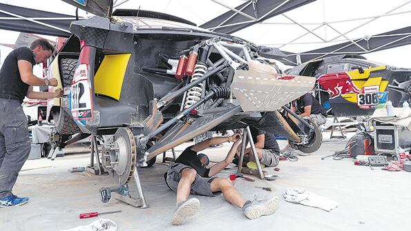 Los mecánicos trabajando en el Peugeot 3008 de Sebastien Loeb. Una rutina que se dio en cada campamento.